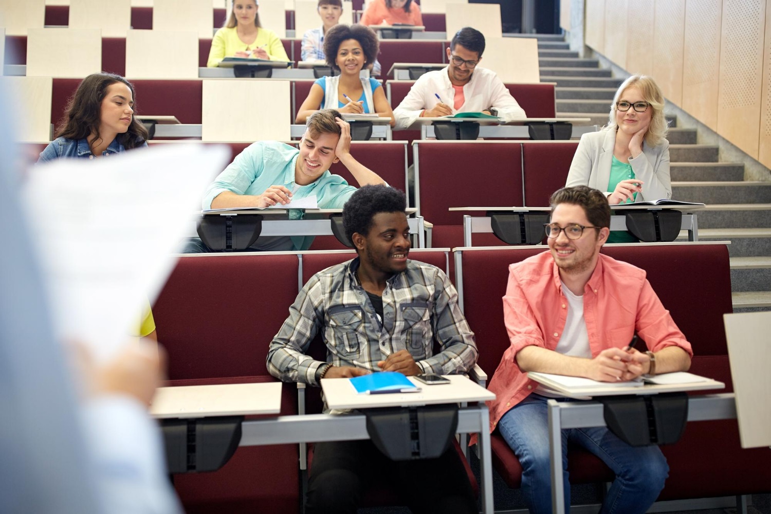 education-high-school-university-learning-people-concept-group-international-students-with-notebooks-talking-lecture-hall