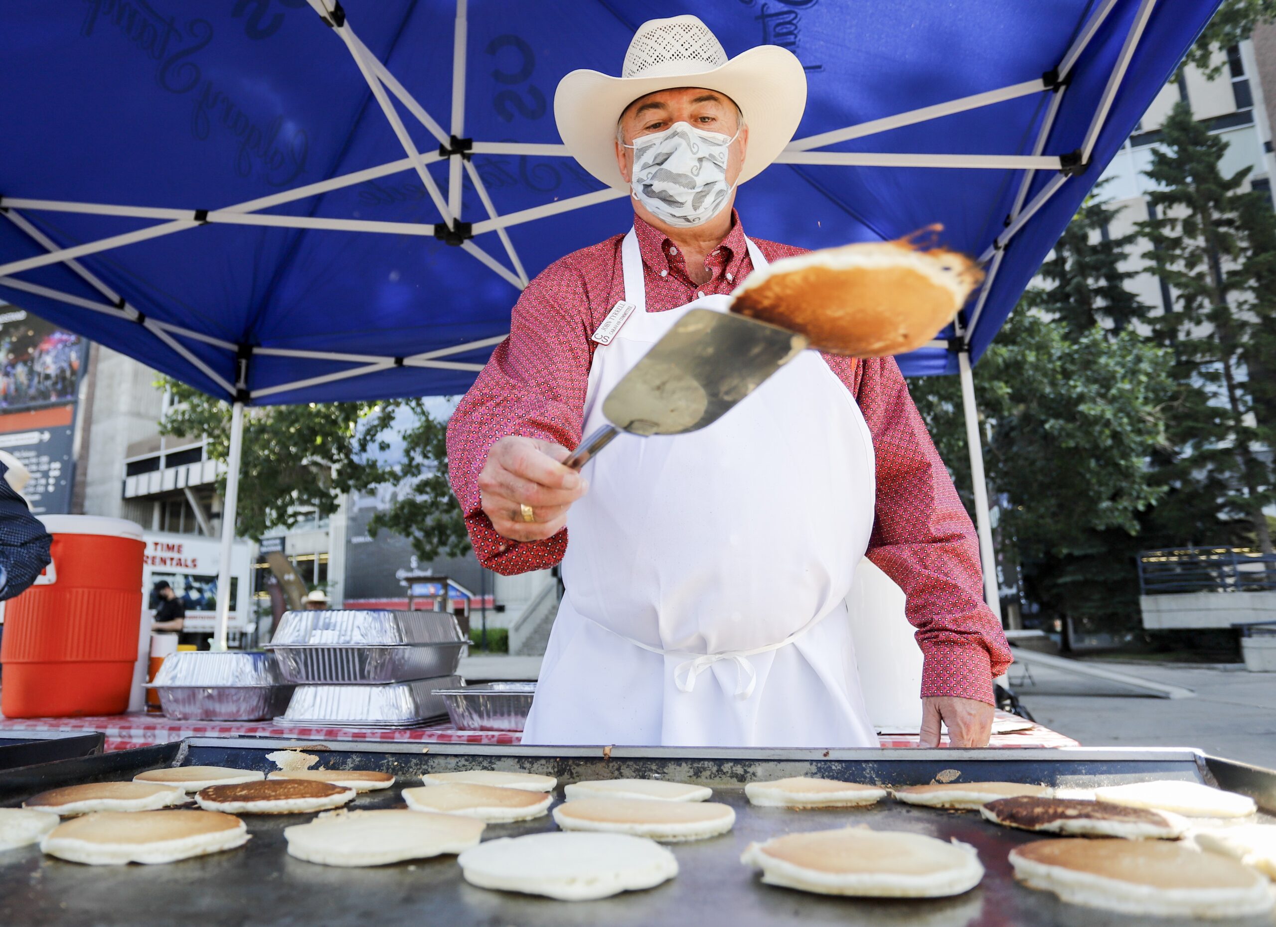 John Tyrrell flips pancakes at the Family Day pancake breakfast during the Calgary Stampede in Calgary, Alta., Friday, July 9, 2021. THE CANADIAN PRESS/Jeff McIntosh